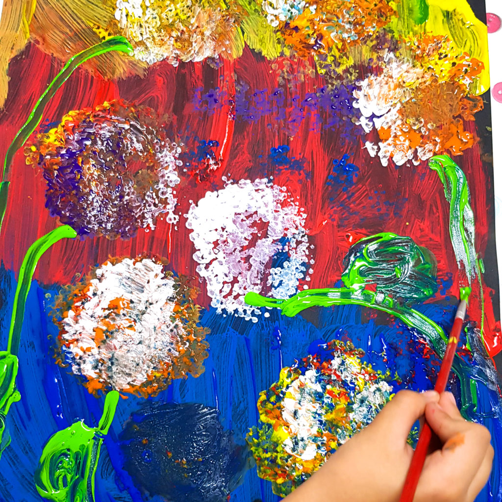 ребенок рисует цветы на черном фоне